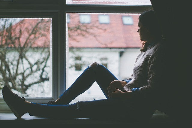 Depressed girl on a window ledge