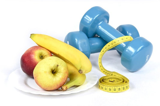A measure tape, fruits and dumbbells