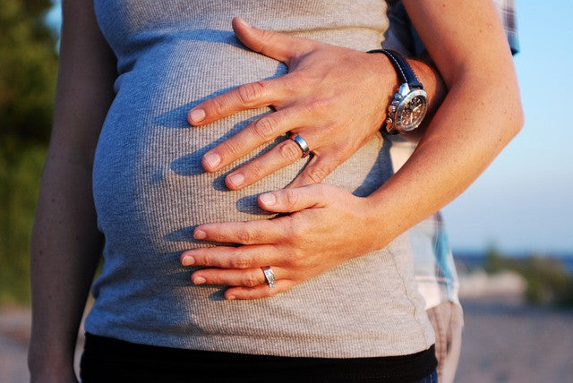 Pregnant woman and man's hand