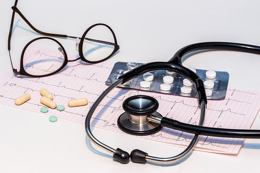 Cardiogram, stethoscope, pills and glasses