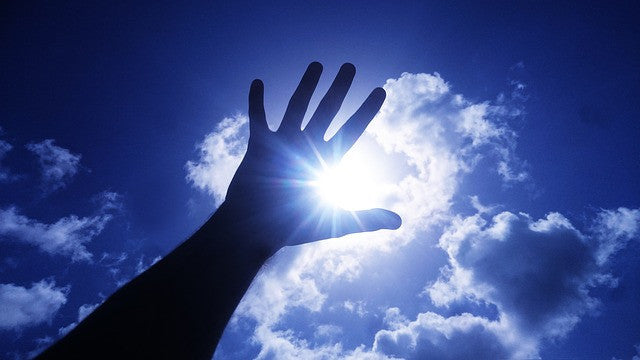 Hand, sun and blue sky